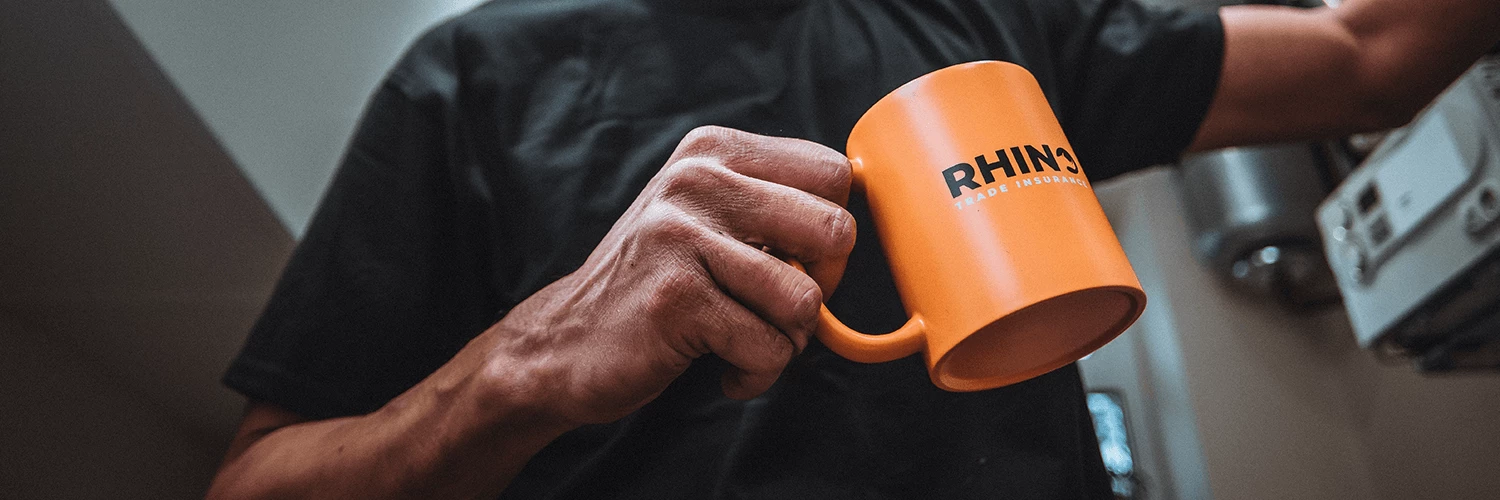 Man holding Rhino Trade Insurance branded mug for Garage Door installers