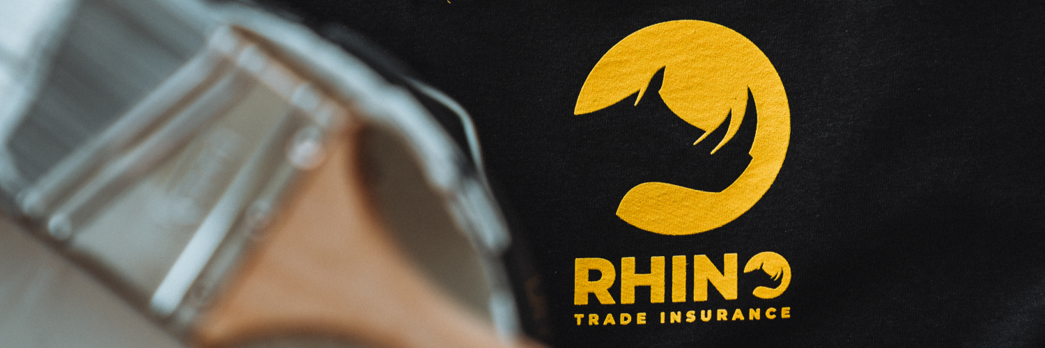 paintbrush and paint bucket on rhino trade insurance shirt