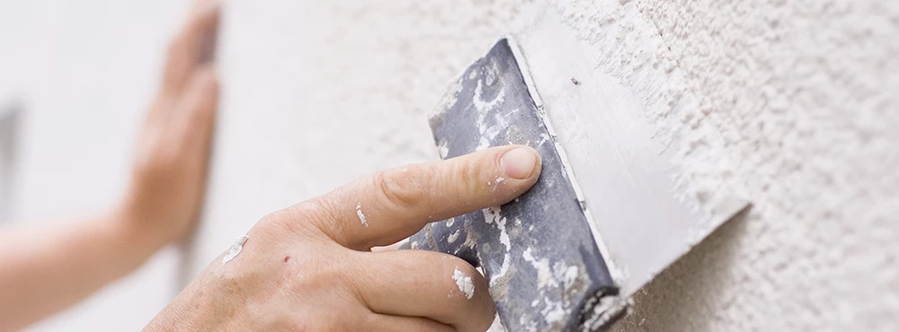 Hand craping off rough surface on wall