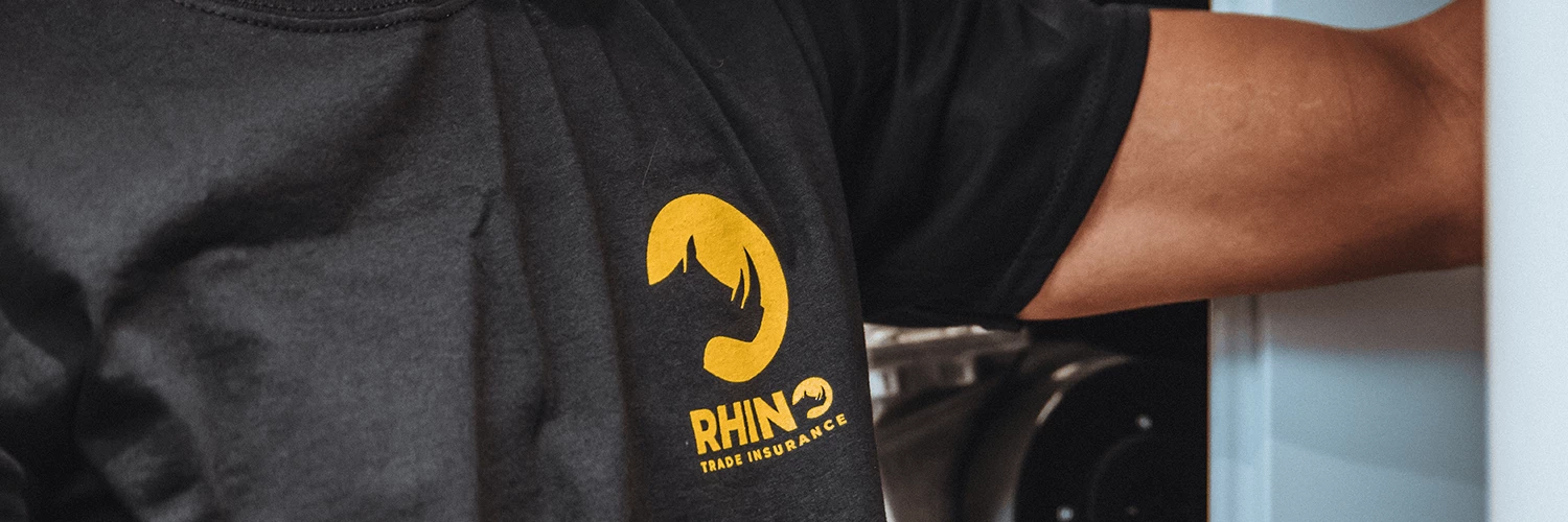 Close up image of person wearing Rhino Trade Insurance t-shirt fitting gas